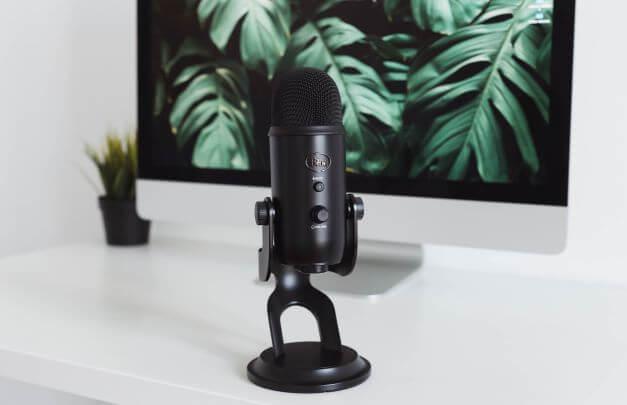 Podcast microphone in front of computer monitor 